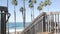 Wooden stairs, beach access in California USA. Coastal stairway, pacific ocean waves and palm trees.