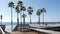 Wooden stairs, beach access in California USA. Coastal stairway, pacific ocean waves and palm trees.