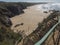 Wooden stairs leading to Praia do Brejo Largo beach with ocean waves and sharp stones, cliffs and sand at Rota Vicentina