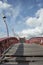 Wooden stairway with red banister in the blue sky