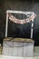 Wooden stand or stall with artificial web and garland with trick or treat inscription on a black background.