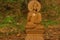 Wooden statue of Buddha in forest, namaste