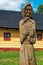 Wooden statue of villager in front of picturesque historical village Vlkolinec witjh wooden colorful cottages in Slovakia