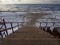Wooden steps down to the sandy beach in the Baltic Sea on a winter cloudy day at sunset in Klaipeda, Lithuania