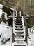 Wooden steps near the cliff. Staircase made of wood in the snow. Wooden structure for climbing the mountain