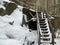 Wooden steps near the cliff. Staircase made of wood in the snow. Wooden structure for climbing the mountain