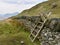 Wooden stile over stone wall