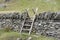 Wooden stile over stone wall