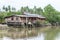 Wooden stilt house beside a canal in Samut Songkhram province, Thailand. At a boat tour from Amphawa Floating Market