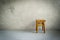 Wooden stool in empty room. Chair on cement floor. Grunge interior