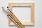 Wooden stretcher bar and paintbrushes on white artist canvas background.