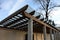 Wooden structure of the pergola supported by smooth cylindrical white columns shelter of a gazebo pergola. roof lined with glass.