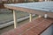 Wooden structure of the pergola supported by smooth cylindrical white columns shelter of a gazebo pergola. roof lined with glass.