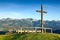 Wooden summit cross with scenic view to mountain range