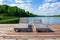 Wooden sun loungers on pier on lake