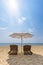 Wooden sunbeds and umbrella on the golden sand of a beach