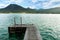 Wooden swimming platform as bridge pier deck on alpine lake with beautiful green turquoise clear water during Summer