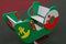 Wooden swing-boat mounted on powerful spring, painted green with white seats inside with yellow anchor and red and white lifebuoy