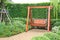 Wooden swing chair in natural green garden. Beautiful garden furniture