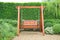 Wooden swing chair in natural green garden. Beautiful garden furniture