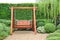 Wooden swing chair in natural green garden. Beautiful garden furniture