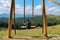 Wooden Swing on Mountain Meadow: A Serene Retreat with Majestic Mountain View and Lush Pine Forest. Enjoy a Sunny Summer Day as a