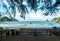 Wooden table with benches on the beach. Empty outdoor beachside tropical tourism. Outdoor on the beach, ocean and sky, tropical