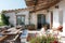 A wooden table and benches are set up on a patio, providing a functional outdoor seating area, A rustic Mediterranean seaside