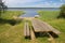 Wooden table with benches on the shore of lake