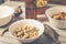 On a wooden table a bottle of beer, dried fish, chips, crackers and nuts