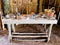 Wooden table covered with clay pottery, bowls, cups, baskets and more inside a Native American Summer House