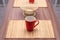 Wooden table with decorative napkins and red cups for tea. Dining room interior