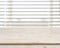 Wooden table on defocuced window with venetian blinds background