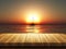 Wooden table with defocussed sunset sea image