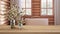 Wooden table, desk or shelf close up with branches of cherry blossoms in glass vase over blurred view of log cabin bathroom with