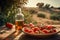 On a wooden table in the field, some tomatoes and a bottle of oil.