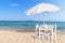 Wooden table with four chair on beautiful sandy beach and blue s