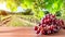Wooden table with fresh red grapes and free space on nature blurred background, vineyard field. Generated AI.
