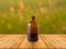 Wooden table in front of bokeh background with brown bottle