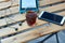 Wooden table with glass of black strong coffee and mobile headphones, smartphone and e-book. Work and study in cafe.