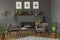 Wooden table between grey armchairs in retro flat interior with