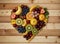 A wooden table with a heart made out of various fruits on it