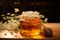 Wooden table holds glass jar brimming with natures sweet golden honey