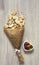 Wooden table lies pile crumpled paper with a cookie form hearts and a powdered multi-colored heart vase with colorful candies