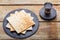 On a wooden table, matzah and a glass of kiddush wine on black round coasters.