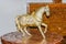 On a wooden table a metal statue of a horse