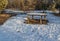 Wooden table for outdoor recreation on the river bank in spring in March, waiting for visitors.