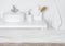 Wooden table over blurred domestic bathroom washbowl background