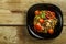 On a wooden table is a plate of boiled mung bean with vegetables and mushrooms. Copy space.