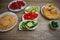 Wooden table with plates with chopped vegetables and crackers. Quick and healthy snacks. Buffet. Lots of fresh vegetables. Cheese